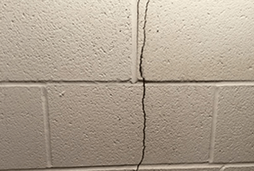 Large crack in white brick foundation