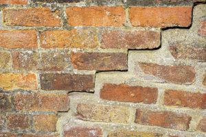 Basement Wall Made of Brick with A Crack That Needs To be Repaired 