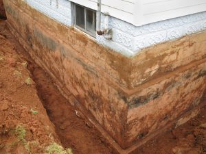 Exterior of basement wall surrounded by dug trench