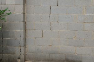 Exterior Brick Wall Painted White With Cracks Caused By Foundation Problems