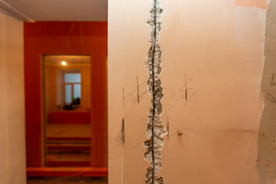 Large Vertical Crack In A Basement Wall With Markings On Either Side